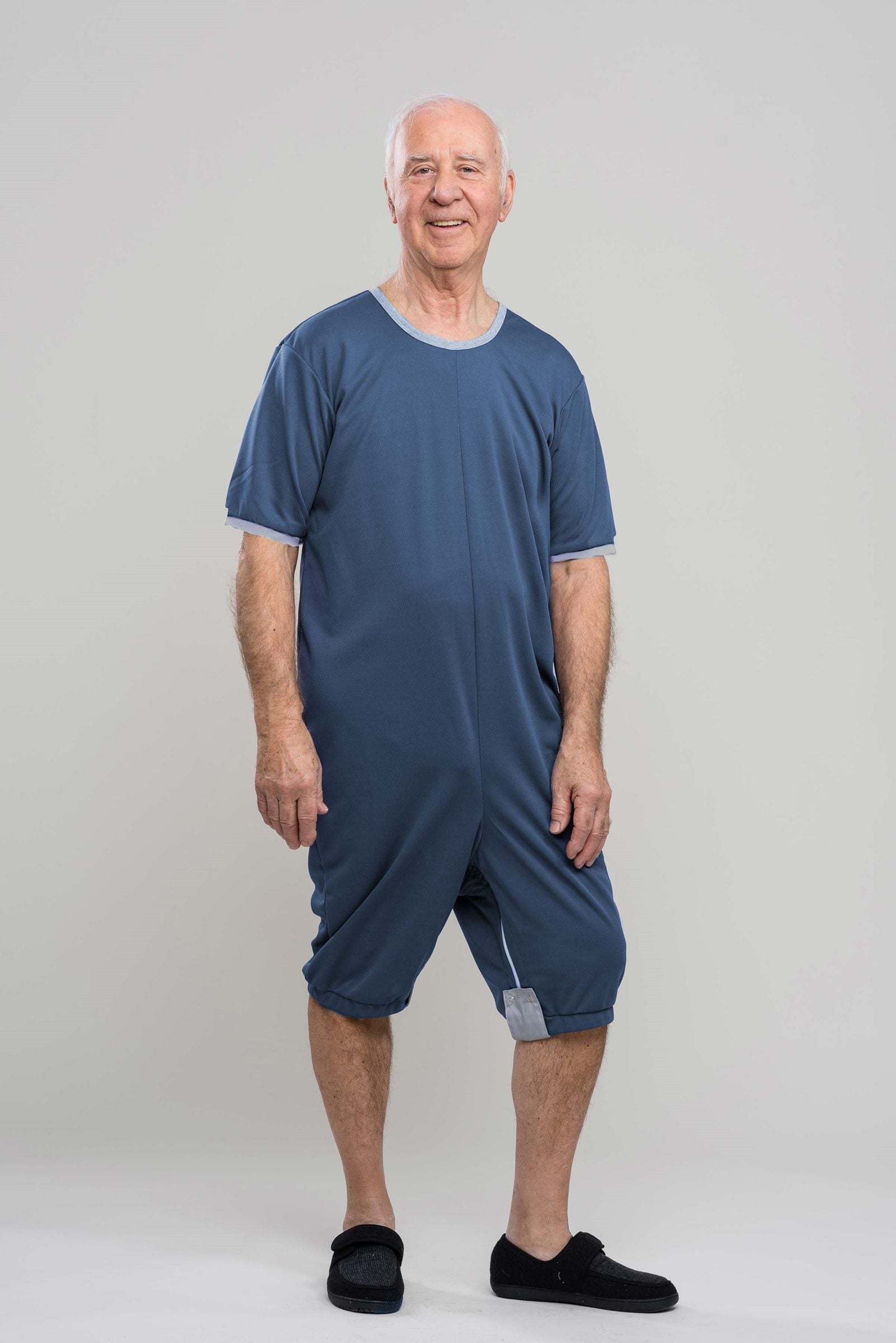 Adaptive short legs onesie designed for people suffering from dementia. A zipper on the back of the garment prevents the wearer from undressing.  A large, zippered crotch opening facilitates diaper changes.  Durable soft mesh knit dries quickly. Can be wo