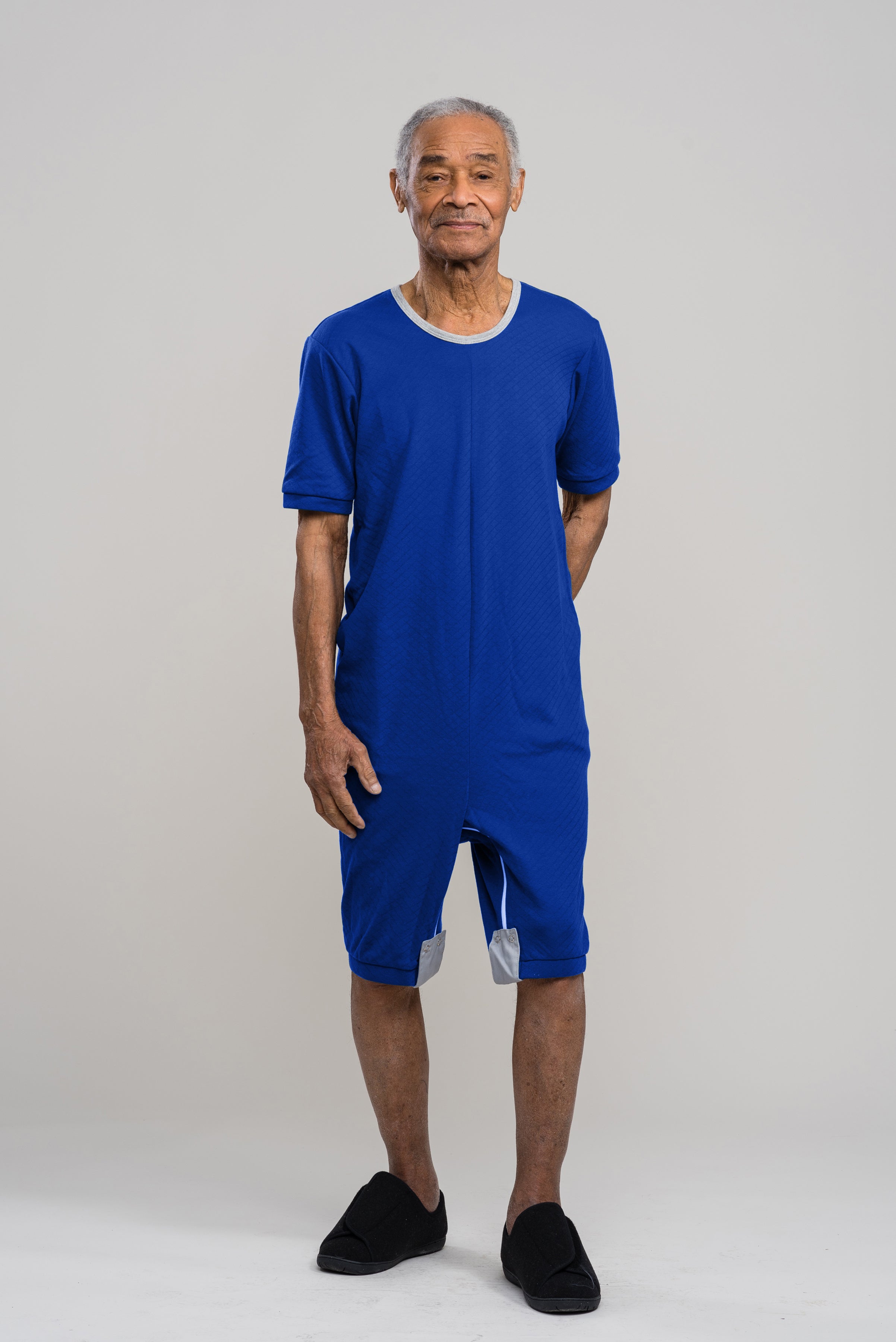 Adaptive short legs onesie designed for people suffering from dementia. A zipper on the back of the garment prevents the wearer from undressing.  A large, zippered crotch opening facilitates diaper changes.  Durable soft mesh knit dries quickly. Can be wo