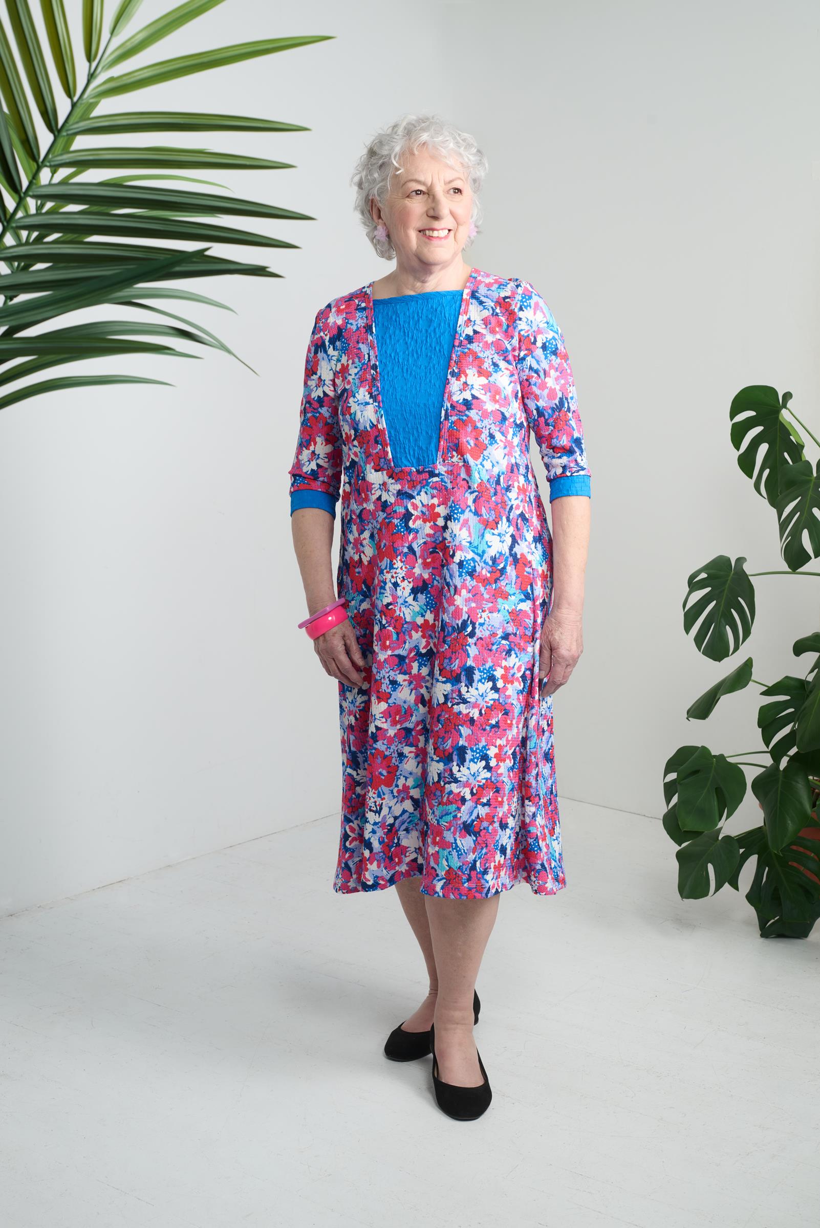 This adaptive dress is perfect for those with limited mobility. The 3/4 sleeves and open back make dressing easier, while the metal snaps provide a secure closure. The knit fabric is comfortable and the graphic floral pastel pattern adds a touch of style.