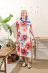 This adaptive dress features a stretch knit material and short sleeves for comfortable wear. The large opening and metal shoulder snaps make dressing and undressing easy for individuals with limited mobility. The daring flower design in white and orange a